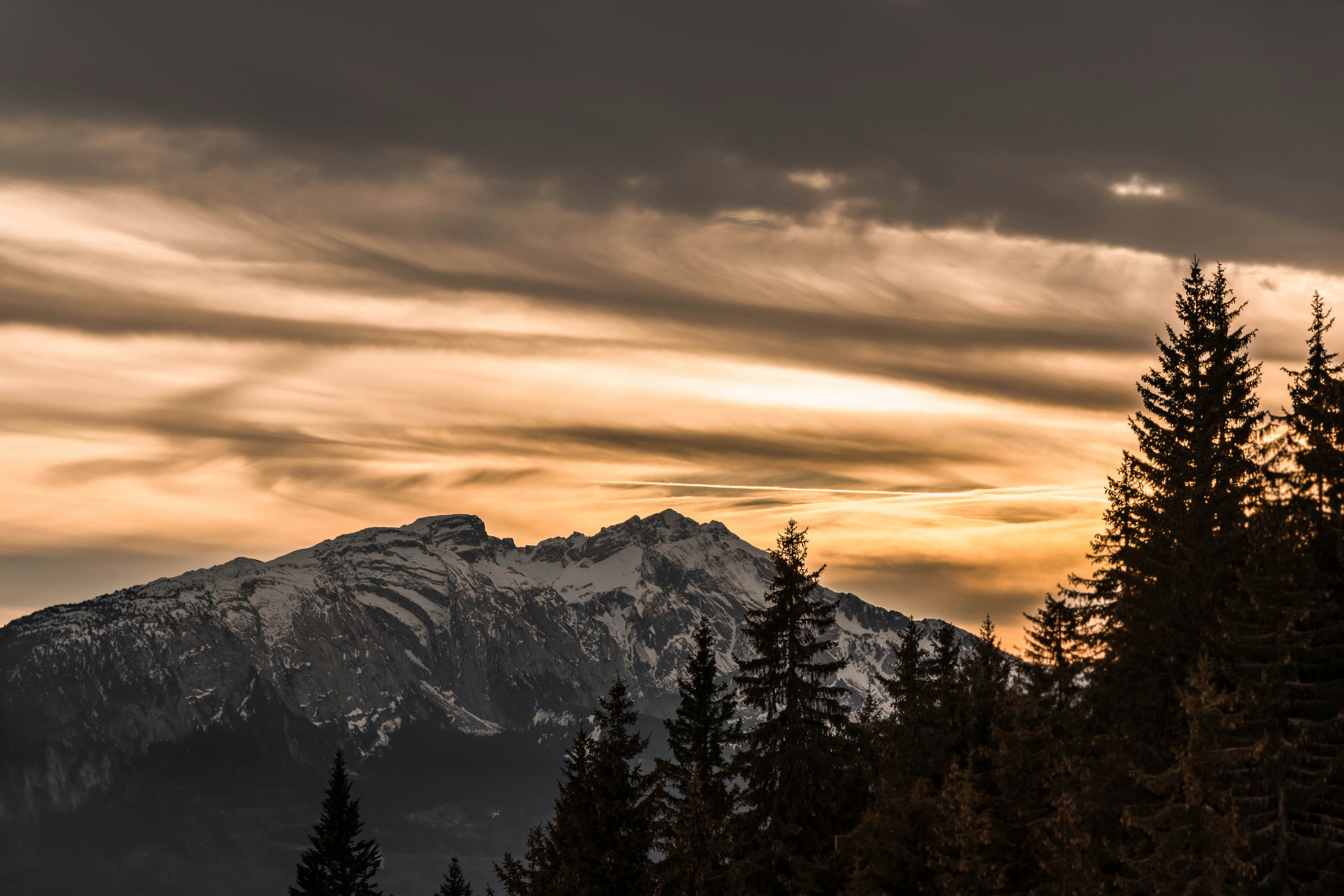 snow covered mountain during sunset